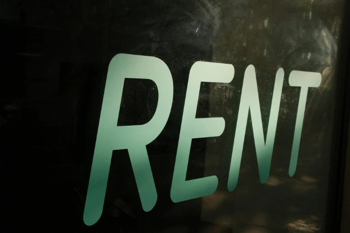 The word rent is written on a dark surface.